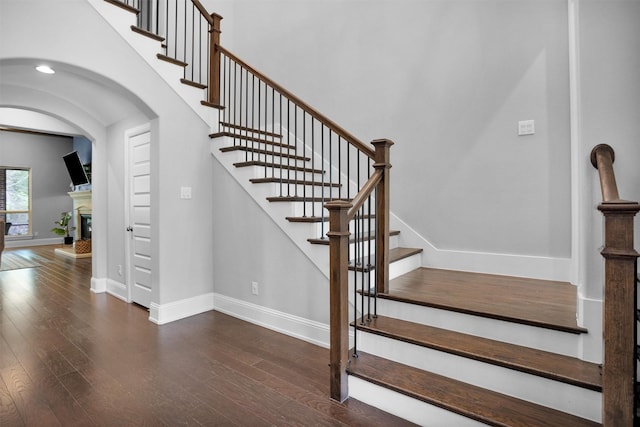 27016 Hidden Grove Landing Dr, Spring, TX 77386 - stairway with wood finished floors, a glass covered fireplace, and arched walkways
