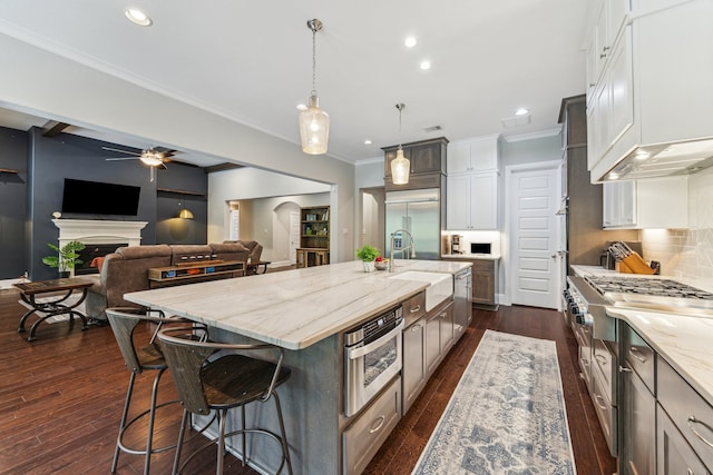 27016 Hidden Grove Landing Dr, Spring, TX 77386 - kitchen with appliances with stainless steel finishes, a ceiling fan, light stone counters, recessed lighting, and a spacious island