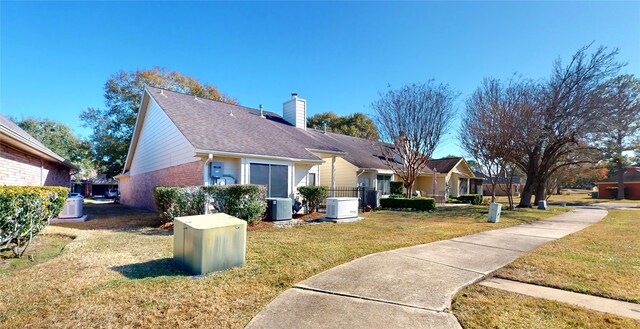 3011 Flower Field Ln, Pearland, TX 77584 - view of property exterior featuring a yard, a chimney, brick siding, and a shingled roof