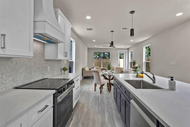 2413 Harlem St, Houston, TX 77020 - kitchen with stainless steel appliances, premium range hood, recessed lighting, open floor plan, and healthy amount of natural light