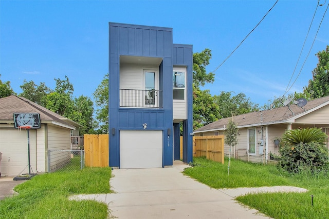 2413 Harlem St, Houston, TX 77020 - view of front facade featuring board and batten siding, driveway, an attached garage, and a balcony