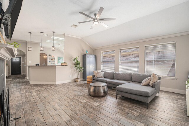 2884 Shallow Brook Ln, League City, TX 77539 - living room with ornamental molding, a ceiling fan, wood finished floors, healthy amount of natural light, and vaulted ceiling