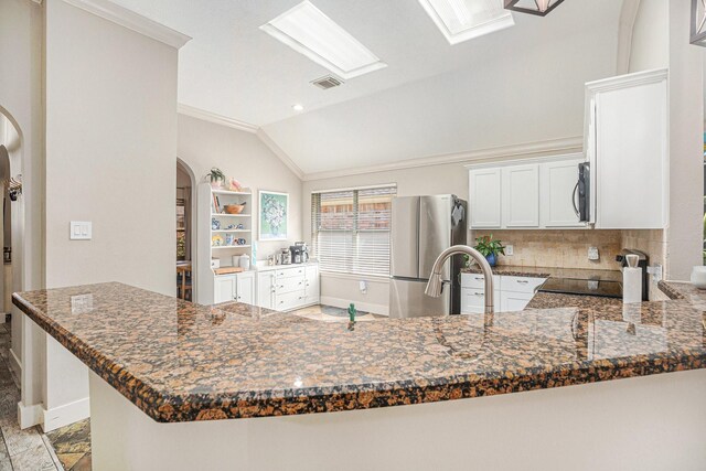 2884 Shallow Brook Ln, League City, TX 77539 - kitchen featuring freestanding refrigerator, arched walkways, lofted ceiling, crown molding, and tasteful backsplash