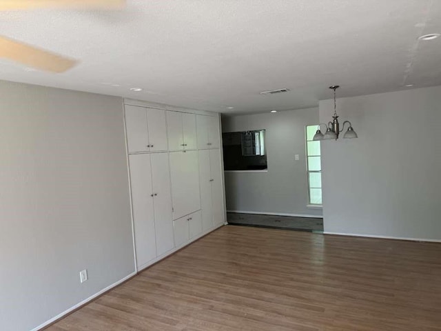 881 Wax Myrtle Ln Unit A, Houston, TX 77079 - empty room with light wood-style flooring and a chandelier