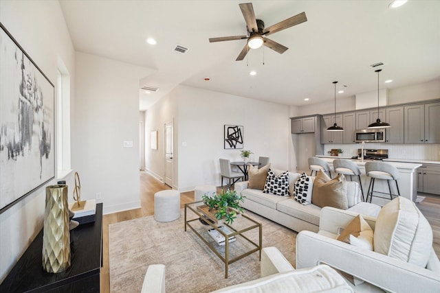5256 Texas St, Houston, TX 77011 - living room with light wood-type flooring, a ceiling fan, and recessed lighting