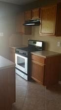 3906 Suttonford Dr, Houston, TX 77066 - kitchen with stainless steel range, range hood, brown cabinets, and light countertops