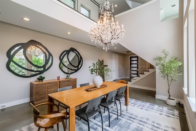 1906 Park St, Houston, TX 77019 - dining space featuring finished concrete flooring, a chandelier, stairway, recessed lighting, and a towering ceiling