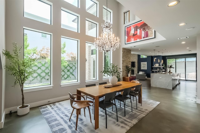 1906 Park St, Houston, TX 77019 - dining space with finished concrete flooring, a chandelier, recessed lighting, and a towering ceiling