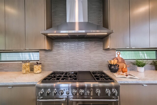1906 Park St, Houston, TX 77019 - kitchen featuring stainless steel stove, wall chimney range hood, tasteful backsplash, and modern cabinets