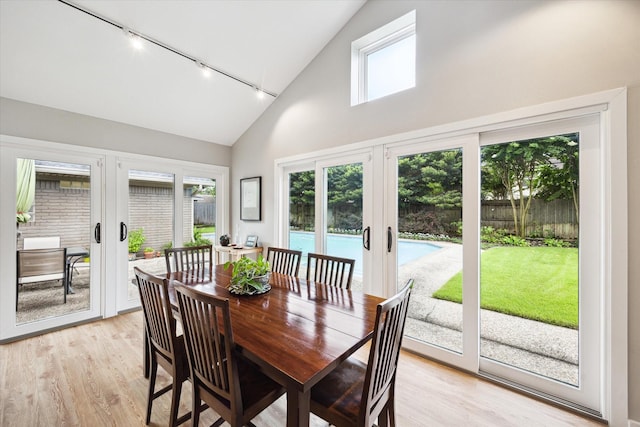 5171 Jason St, Houston, TX 77096 - dining room featuring rail lighting, french doors, high vaulted ceiling, and light wood finished floors