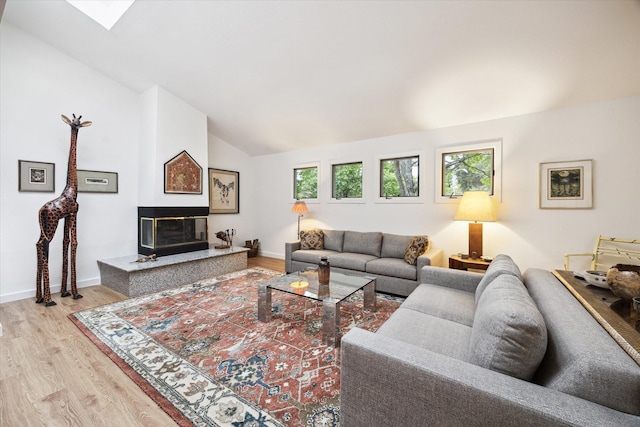 5171 Jason St, Houston, TX 77096 - living area featuring light wood-style flooring, lofted ceiling, and a glass covered fireplace