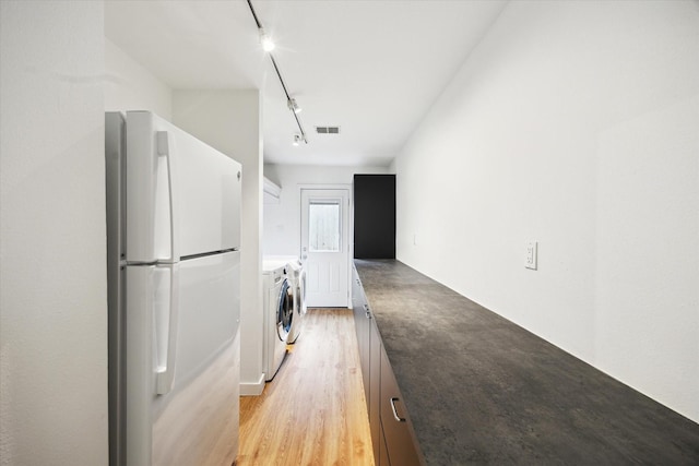 5171 Jason St, Houston, TX 77096 - washroom featuring washing machine and dryer, track lighting, and light wood finished floors