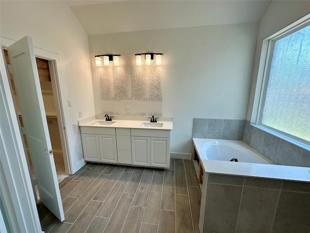 13085 Brookwood Bend Ln, Conroe, TX 77302 - bathroom featuring a garden tub, wood finished floors, a spacious closet, and double vanity