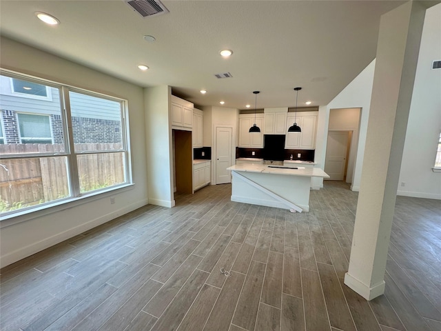 13085 Brookwood Bend Ln, Conroe, TX 77302 - kitchen featuring light wood finished floors, white cabinetry, light countertops, recessed lighting, and decorative light fixtures