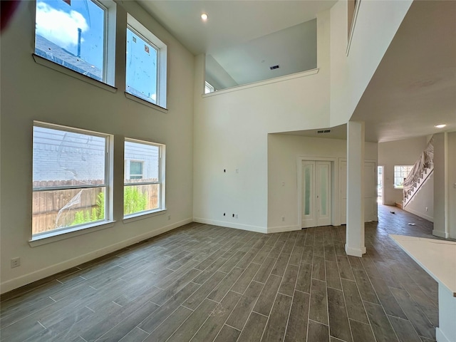 13085 Brookwood Bend Ln, Conroe, TX 77302 - unfurnished living room featuring plenty of natural light, dark wood-style flooring, stairway, and recessed lighting