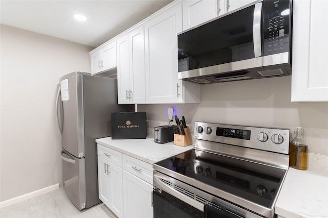 9106 Gustine Ln, Houston, TX 77031 - kitchen featuring appliances with stainless steel finishes, white cabinets, light stone countertops, and recessed lighting