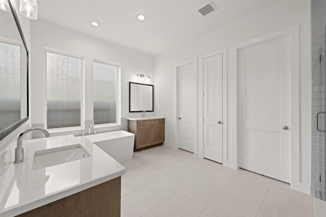 12814 Forest Garden Ct, Conroe, TX 77302 - bathroom with two vanities, tile patterned floors, recessed lighting, and a stall shower