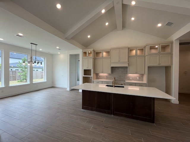 12814 Forest Garden Ct, Conroe, TX 77302 - kitchen featuring dark wood-type flooring, decorative backsplash, a spacious island, a chandelier, and glass insert cabinets