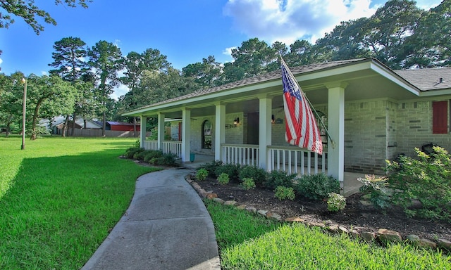 2102 Candy St, Pinehurst, TX 77362 - view of front of house with a porch, a front yard, brick siding, and roof with shingles