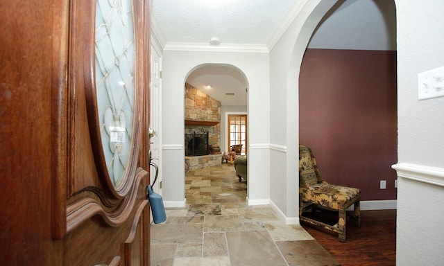 2102 Candy St, Pinehurst, TX 77362 - entryway featuring arched walkways, a stone fireplace, ornamental molding, and stone tile flooring