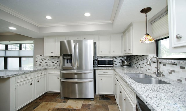 2102 Candy St, Pinehurst, TX 77362 - kitchen with appliances with stainless steel finishes, a raised ceiling, ornamental molding, white cabinets, and a peninsula