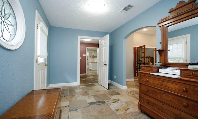 2102 Candy St, Pinehurst, TX 77362 - entrance foyer featuring arched walkways, stone tile flooring, and a textured ceiling