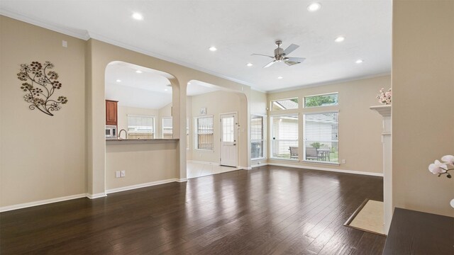 9138 Shango Ln, Houston, TX 77095 - unfurnished living room featuring crown molding, arched walkways, recessed lighting, a ceiling fan, and dark wood-style floors