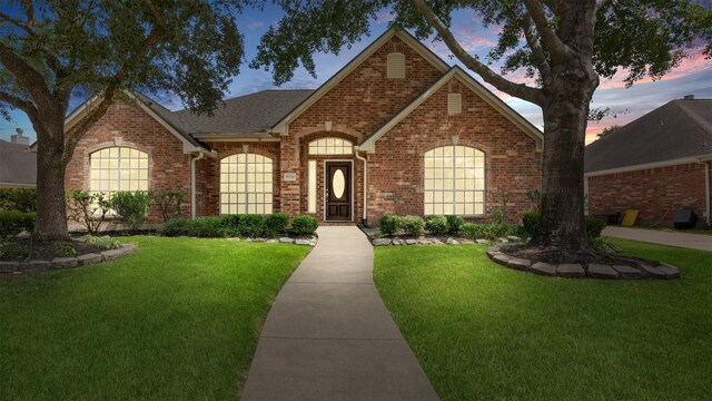 9138 Shango Ln, Houston, TX 77095 - view of front of house with brick siding, a front lawn, and a shingled roof
