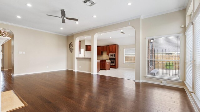 9138 Shango Ln, Houston, TX 77095 - unfurnished living room featuring arched walkways, ceiling fan, healthy amount of natural light, ornamental molding, and recessed lighting