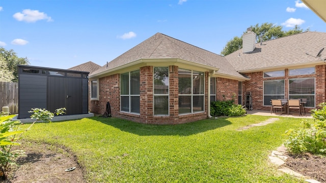 9138 Shango Ln, Houston, TX 77095 - back of property featuring a shingled roof, brick siding, a patio, a chimney, and a shed