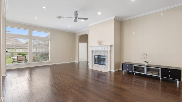 9138 Shango Ln, Houston, TX 77095 - unfurnished living room featuring arched walkways, wood finished floors, ceiling fan, crown molding, and a tile fireplace