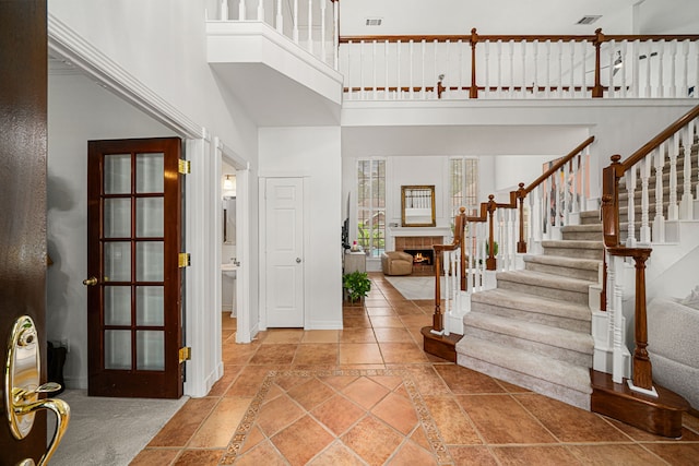 12927 Finch Brook Dr, Cypress, TX 77429 - foyer featuring a high ceiling, inlaid floor details, stairway, and a lit fireplace