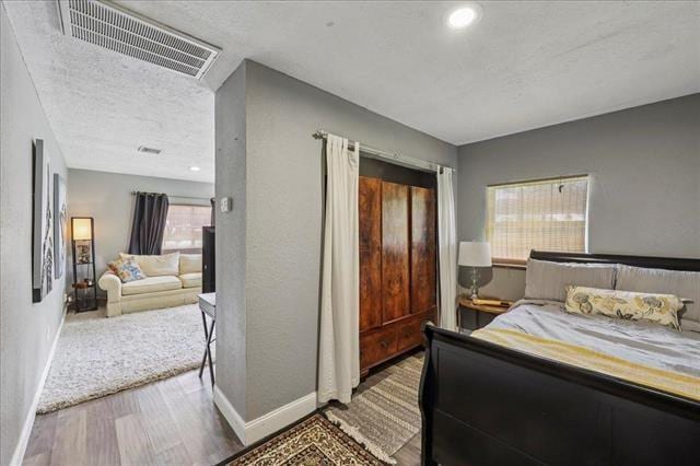 3231 Charles Ave, Groves, TX 77619 - bedroom featuring wood finished floors and a textured ceiling
