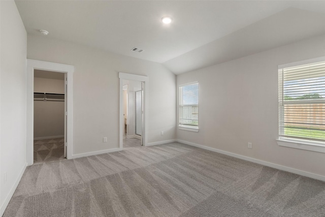 2971 Colonia Blossom Ln, Pinehurst, TX 77362 - unfurnished bedroom featuring carpet flooring, a walk in closet, lofted ceiling, a closet, and ensuite bath
