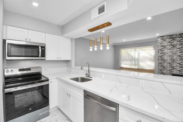 17202 Imperial Valley Dr Unit 3, Houston, TX 77060 - kitchen with stainless steel appliances, light marble finish flooring, white cabinetry, and recessed lighting