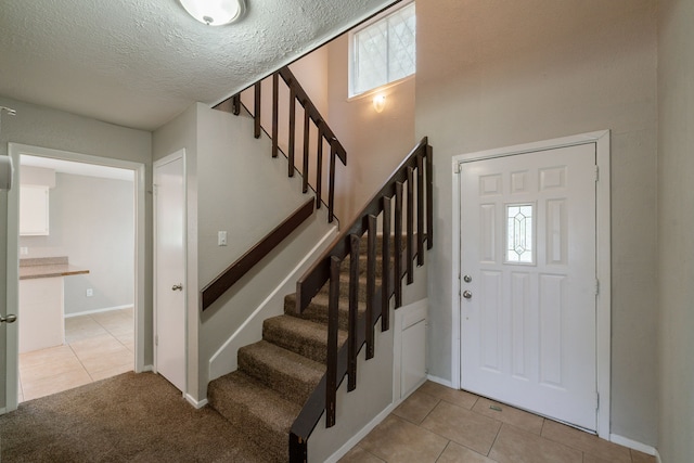 10006 Peachridge Dr, Houston, TX 77070 - foyer with stairs, light tile patterned floors, and a textured ceiling