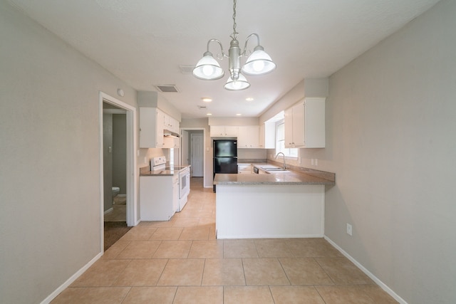 10006 Peachridge Dr, Houston, TX 77070 - kitchen with white electric range oven, freestanding refrigerator, a chandelier, light tile patterned floors, and white cabinets