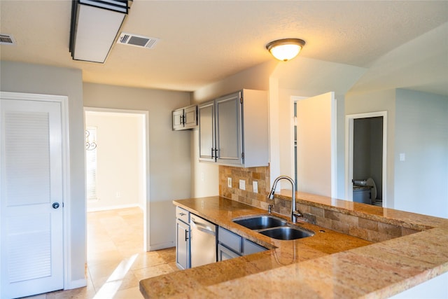 6311 Laurel Bush Ln, Sugar Land, TX 77479 - kitchen featuring stainless steel dishwasher, light stone countertops, tasteful backsplash, and a peninsula