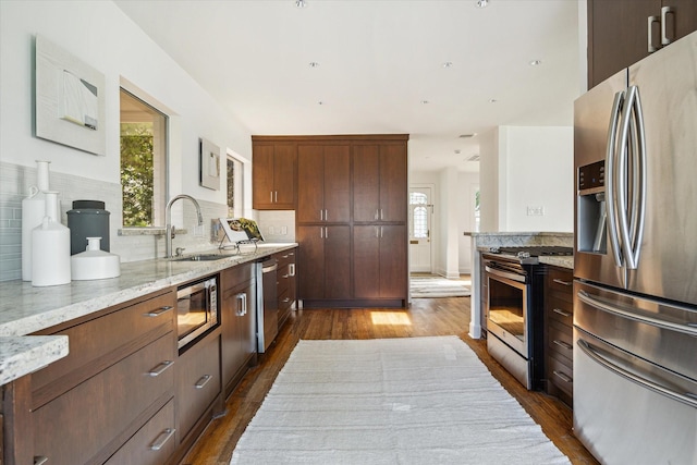 2037 Banks, Houston, TX 77098 - kitchen featuring appliances with stainless steel finishes, dark wood-type flooring, tasteful backsplash, and light stone countertops