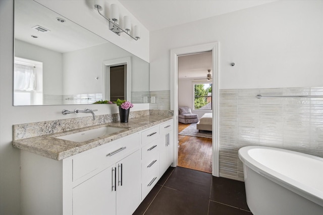 2037 Banks, Houston, TX 77098 - ensuite bathroom featuring vanity, a soaking tub, tile patterned flooring, tile walls, and a wainscoted wall