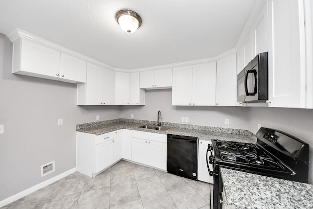 4522 Larkspur St, Houston, TX 77051 - kitchen featuring black appliances, white cabinetry, light stone counters, and light tile patterned floors