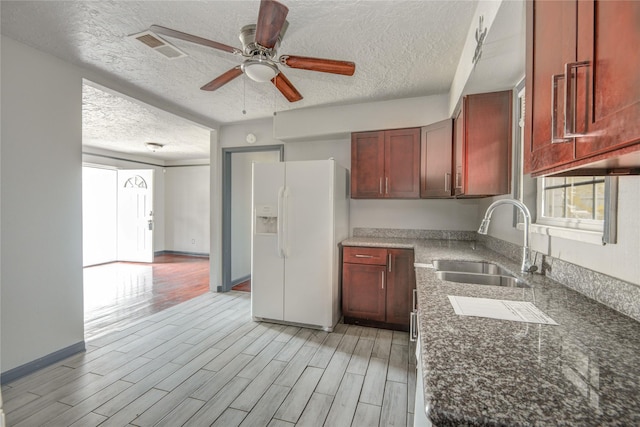 422 Gammon Dr, Houston, TX 77022 - kitchen with white refrigerator with ice dispenser, a textured ceiling, a ceiling fan, light wood-style flooring, and dark brown cabinets