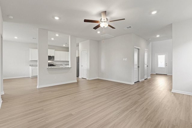 10811 Bright Beacon Dr, Beasley, TX 77417 - unfurnished living room featuring ceiling fan, light wood-style flooring, and recessed lighting