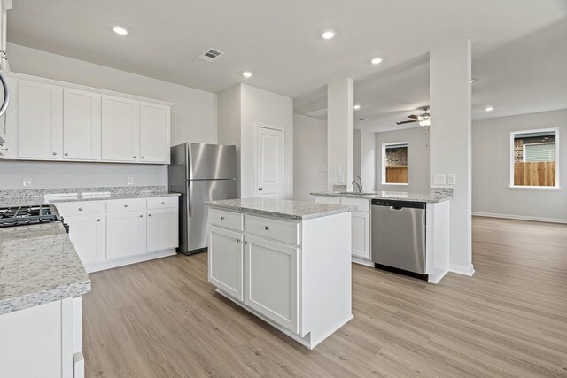 10811 Bright Beacon Dr, Beasley, TX 77417 - kitchen featuring stainless steel appliances, light wood-style floors, ceiling fan, light stone countertops, and recessed lighting