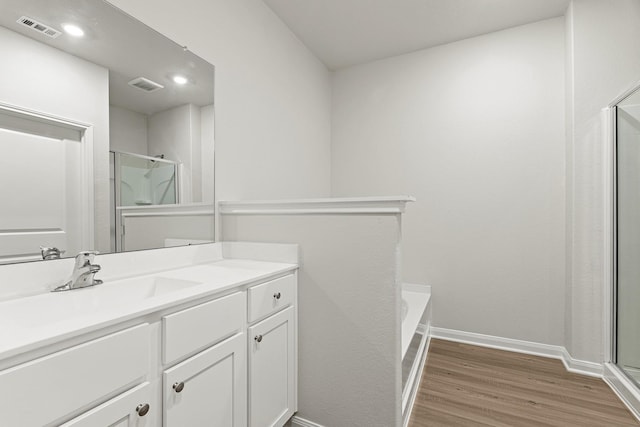 10811 Bright Beacon Dr, Beasley, TX 77417 - full bathroom featuring wood finished floors, a shower with shower door, vanity, and a tub