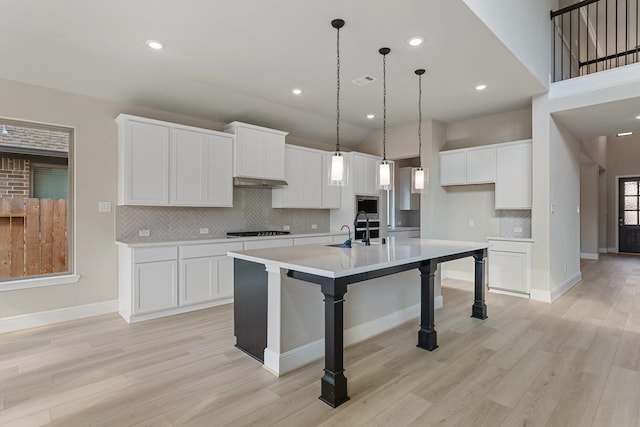 914 Hooks Trl, League City, TX 77573 - kitchen with stovetop, backsplash, light countertops, light wood-style floors, and recessed lighting