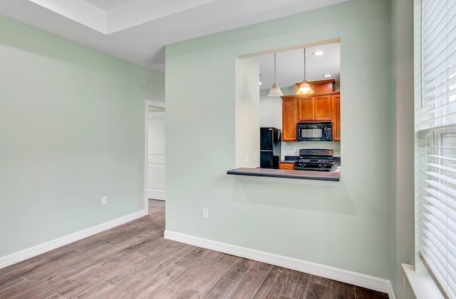 2245 Wilson St, Beaumont, TX 77703 - kitchen featuring black appliances, brown cabinets, wood finished floors, recessed lighting, and hanging light fixtures