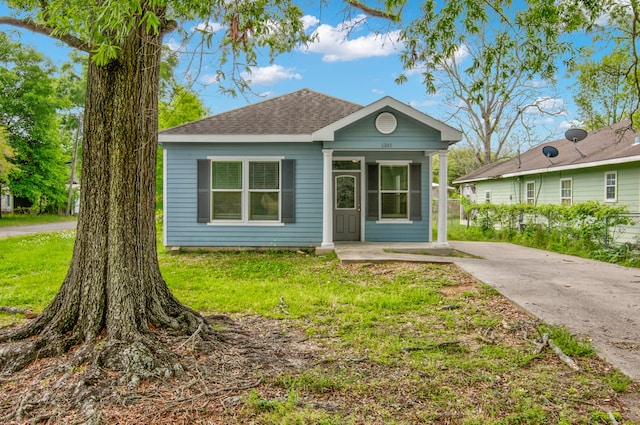2245 Wilson St, Beaumont, TX 77703 - view of front of home with a front yard, a shingled roof, and covered porch