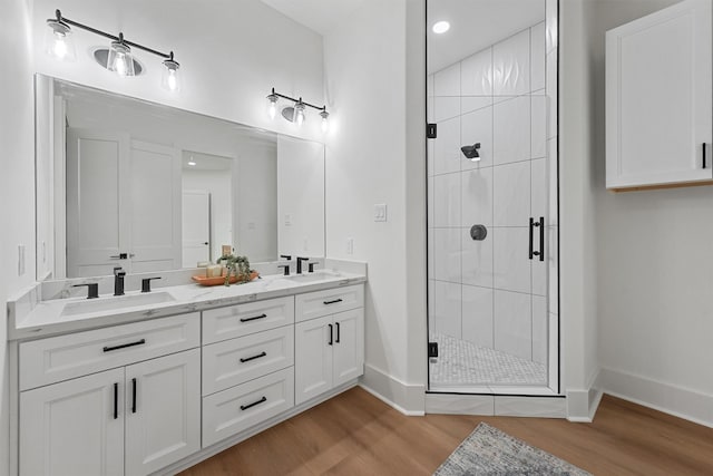 21330 Scissor Tail Ln, Galveston, TX 77554 - full bathroom with double vanity, wood finished floors, a stall shower, and recessed lighting