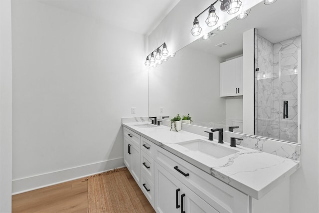 21330 Scissor Tail Ln, Galveston, TX 77554 - full bath featuring double vanity, a marble finish shower, and wood finished floors